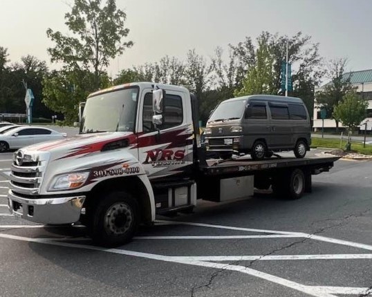 Minivan Sitting on a Flatbed Tow Truck